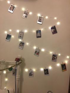 a bedroom with lights strung from the ceiling and pictures hanging on the wall above it