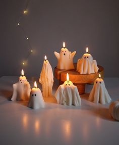 some white candles with ghost faces on them