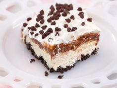 a piece of cake on a plate with chocolate chips and cream frosting in the middle