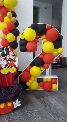 the number twenty seven is made up of balloons and mickey mouse decorations for a birthday party