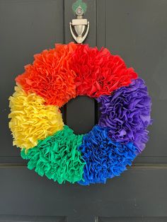 a rainbow colored wreath hanging on the front door