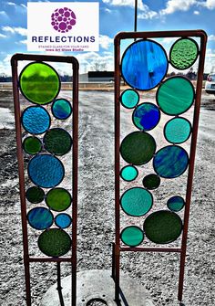 two stained glass panels sitting on top of a cement slab in front of a sign