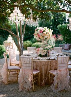 the table is set up for an outdoor dinner party with pink and white flowers on it