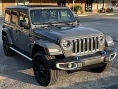 a gray jeep parked in front of a building