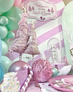 pink and green decorations are on display in front of a wall that has balloons, trees, and other items