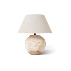 a table lamp with a white shade on it's base and a light bulb in the middle