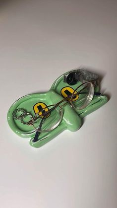 a green keychain with a pair of eye glasses on it's face