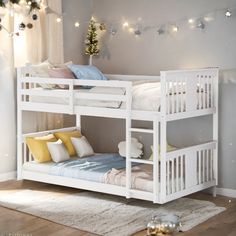 a white bunk bed sitting on top of a hard wood floor next to a christmas tree