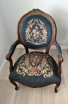 an antique chair with blue upholstered fabric