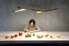 a woman sitting at a table with apples and onions in front of her as she writes