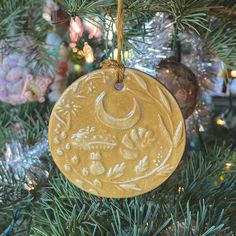 a ceramic ornament hanging from a christmas tree