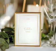 a table setting with wine glasses and place cards