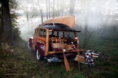 an old vw bus is parked in the woods with its roof open and luggage on it's back