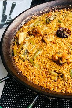 a pan filled with rice and vegetables on top of a table