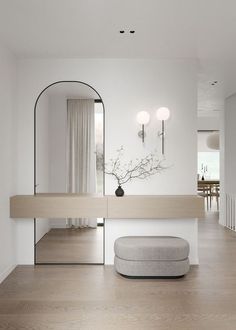 a white room with a mirror on the wall and a stool in front of it