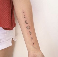 a woman's arm with three phases of the moon tattoo on her left forearm