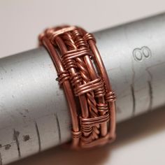 the ring is made from copper wire and sits on top of a metal tube,