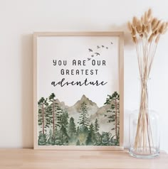 an art print with the words you are our greatest adventure on it next to some dried flowers