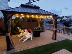 a gazebo sitting on top of a brick patio next to a white lawn chair