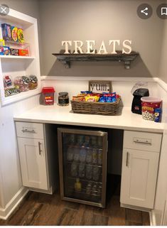 a small kitchen with white cabinets and an ice chest in the corner that has snacks on it