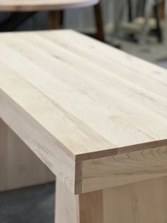 a close up of a wooden table with no people in the room behind it,