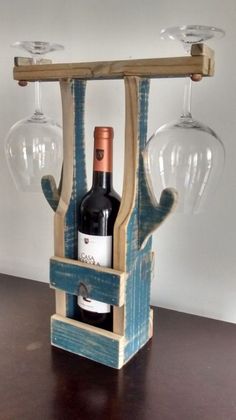 a wine glass holder with two wine glasses on it and a bottle in the middle