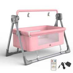 a pink baby crib with two remote controls