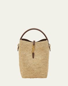 Saint Laurent "Le 37" bucket bag in raffia and leather     Flat top handle, 3.5" drop    Detachable, adjustable crossbody strap, 15.7"L    Can be worn as a top handle, shoulder, or crossbody bag     Open top with center YSL strap     Bronze hardware     Feet protect the bottom of bag     Approx. 9.8"H x 7.8"W x 6.2"D    Imported Designer Bucket Bag For On-the-go, Top Handle Straw Bag With Gold-tone Hardware, Top Handle Bucket Bag With Detachable Strap For Errands, Designer Bucket Bag With Round Handle, On-the-go Straw Bag With Detachable Handle, Designer Bucket Bag With Leather Handles In Natural, Designer Straw Bucket Bag With Leather Handles, Luxury Everyday Straw Crossbody Bag, Designer Natural Bucket Bag With Leather Handles