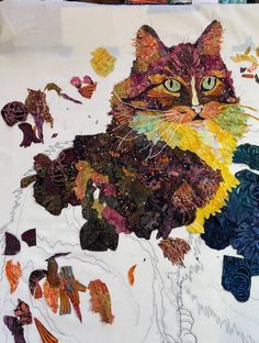 a cat is sitting in the middle of an art project