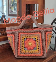 a crocheted bag sitting on top of a wooden table next to a mirror