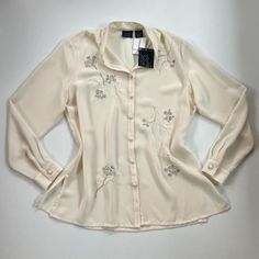 Deadstock Vintage Nwt Cream Button Up Blouse Gorgeous Elegant Florals On A Flowy Cream Background. Would Be So Pretty Tucked Into A Skirt. Originally From Sears. Brand Is Laura Scott. Size Tagged As 1g, But Pit To Pit Is 22", Compare To Maybe A Large. Sleeve Length 25". Great Condition, In Fourth Pic There Are Extremely Light Gray Marks. I Just Don't Want To Try Washing Them Out With Tags On! Have W Me And Can Ship Whenever! #Deadstock #Vintage #90s #Coquette #Cottagecore Classic Spring Blouse With Covered Buttons, Classic Blouse With Covered Buttons For Spring, Elegant Collared Tops With Pearl Buttons, Elegant Button-up Tops With Pearl Buttons, Spring Cream Blouse With Button Cuffs, Cream Blouse With Button Cuffs For Spring, White Button-up Tops With Pearl Buttons, White Button-up Blouse With Pearl Buttons, White Tops With Pearl Buttons For Workwear