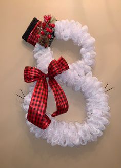 a white wreath with red and black bows