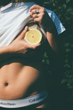 a woman holding a lemon in her stomach