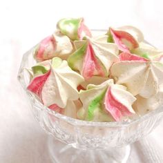 a glass bowl filled with white and pink candy florets on top of a table