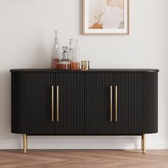 a black and gold sideboard in a white room with a painting on the wall