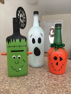 three decorated bottles sitting on top of a counter