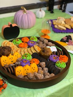 a table topped with lots of different types of cookies and treats on top of a green table cloth