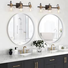 two round mirrors on the wall above double sinks in a white bathroom with gold accents