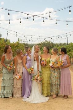 a group of women standing next to each other in front of a string of lights