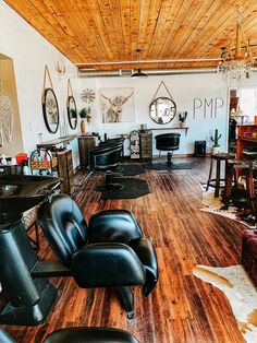 an empty room with chairs, tables and other furniture on the wood floored floor