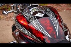 a red motorcycle parked on top of a dirt road