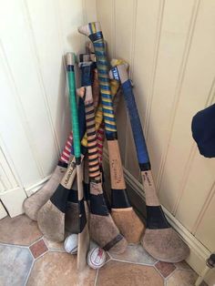 a rack full of baseball bats sitting next to a door with shoes on the floor