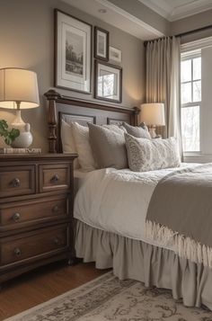 a bedroom with a bed, dresser and two lamps on either side of the window