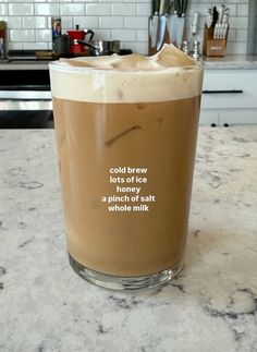 a tall glass filled with liquid sitting on top of a counter