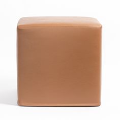 a tan leather ottoman sitting on top of a white floor