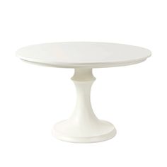 a white cake plate on a white table with an oval base and two round legs