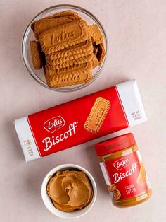 some peanut butter and cookies are on the table next to a container of biscuits