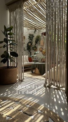 the inside of a room with white curtains and potted plants