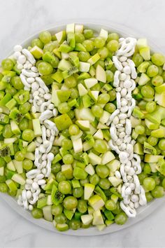 peas, celery, and white beans are arranged in the shape of a letter