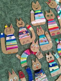 wooden cut out cats are sitting on the floor next to some yarns and crochet